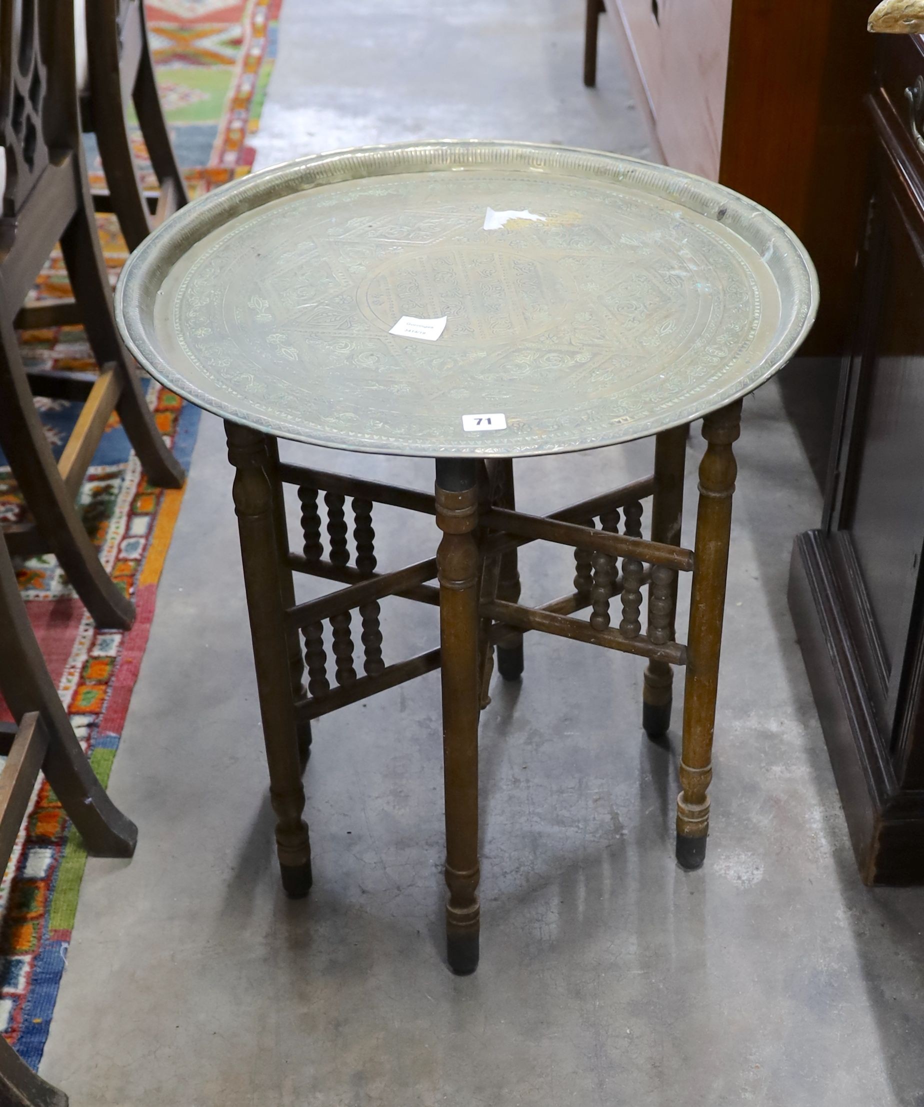 An Indian engraved brass circular tray top folding table, diameter 58cm, height 50cm